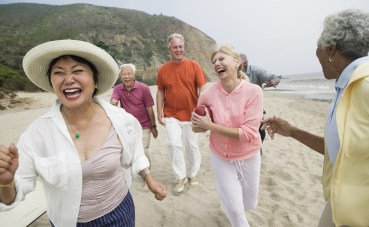 Friends playing american football on beach